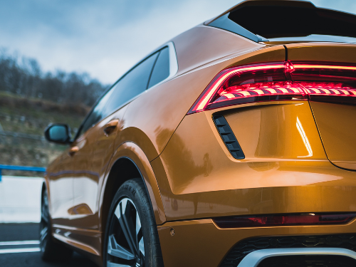 Ein orangefarbener SUV mit markantem Heck und modernen Rücklichtern.