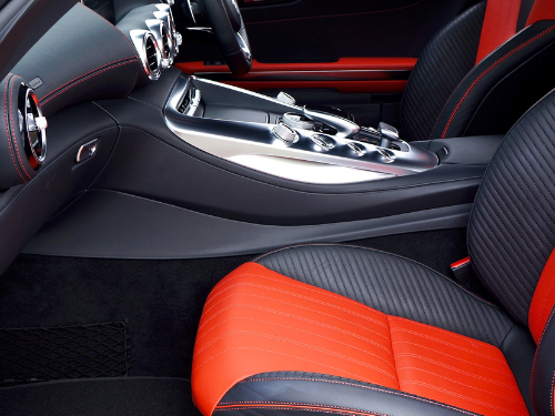 Innenraum eines sportlichen Autos mit schwarzem und rotem Sitzpolster und Konsole.