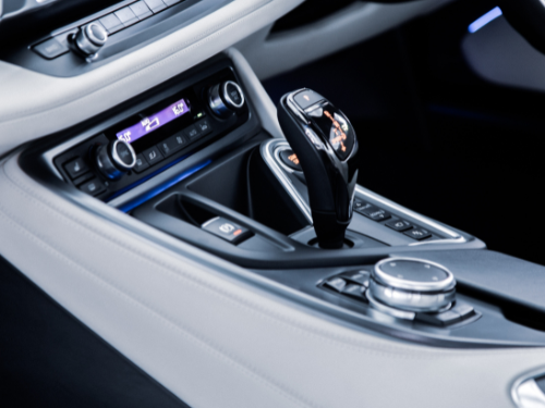 Moderner Auto-Innenraum mit Schalthebel und Bedienelementen für das Infotainmentsystem.