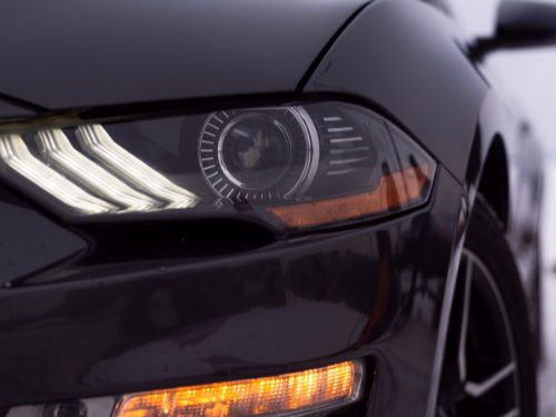 Schwarzes Auto mit markantem Scheinwerfer und LED-Leuchten.